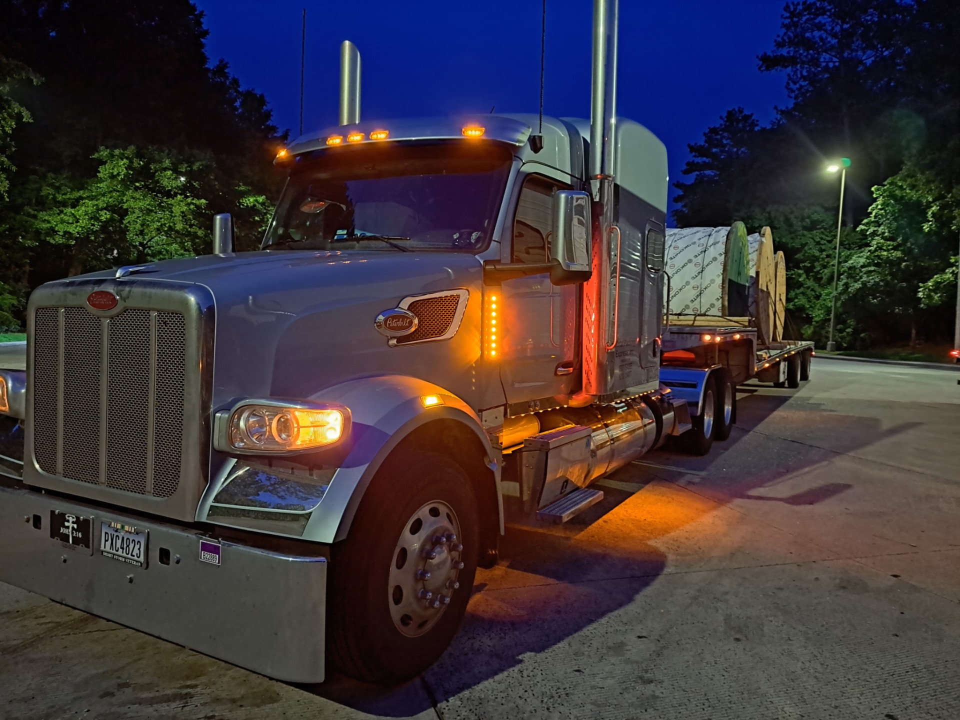 Peterbilt flatbed loaded with cable reels at night